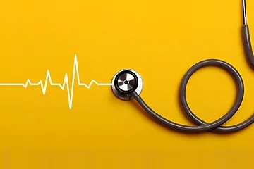 Stetoskop s EKG křivkou na žlutém pozadí